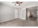 Neutral bedroom features carpet, a ceiling fan, and a glass paneled door to another room at 12021 S Tomi Dr, Phoenix, AZ 85044