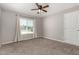 Neutral bedroom features carpet, a ceiling fan, a window and a white closet door at 12021 S Tomi Dr, Phoenix, AZ 85044