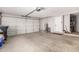 Spacious garage featuring a roll-up door, water heater, and extra storage space at 12021 S Tomi Dr, Phoenix, AZ 85044