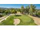 Aerial view of a golf course green with a sand trap, mature trees, and a mountain backdrop at 12021 S Tomi Dr, Phoenix, AZ 85044
