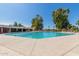 Large outdoor swimming pool with multiple lanes, surrounded by a spacious sun deck and lush greenery at 12021 S Tomi Dr, Phoenix, AZ 85044