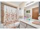 Bright bathroom with a shower-tub combo, vanity, and cabinet at 13207 N 98Th Ave # L, Sun City, AZ 85351