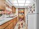 Traditional kitchen with wood cabinets, white appliances, and a view into the breakfast nook at 13207 N 98Th Ave # L, Sun City, AZ 85351