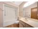 Bathroom featuring a shower and tub combo with white fixtures and wood-finish door at 13224 N 98Th Ave # L, Sun City, AZ 85351