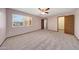 A carpeted bedroom with a window overlooks a charming residential neighborhood at 13224 N 98Th Ave # L, Sun City, AZ 85351