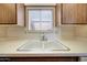 A bright kitchen features a double basin sink under a window and upper cabinets at 13224 N 98Th Ave # L, Sun City, AZ 85351