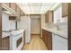 Efficient kitchen with white appliances and wooden cabinets, perfect for cooking at 13224 N 98Th Ave # L, Sun City, AZ 85351