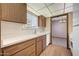 Functional kitchen with wood cabinets and white appliances, leading to living area at 13224 N 98Th Ave # L, Sun City, AZ 85351