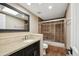 Bathroom featuring a granite vanity, framed mirror, tile surround, and glass shower doors at 14029 N Burning Tree Pl, Phoenix, AZ 85022
