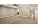 A spacious, carpeted bedroom with a ceiling fan, two electrical outlets, and a bright open doorway at 14029 N Burning Tree Pl, Phoenix, AZ 85022