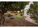 Lush front yard featuring a mature orange tree, garden and stone pathway leading to a white home at 14029 N Burning Tree Pl, Phoenix, AZ 85022