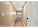 Long hallway with wood-look flooring leading to a carpeted room with a window at the end at 14029 N Burning Tree Pl, Phoenix, AZ 85022
