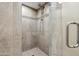 Walk-in shower featuring a glass door, neutral tile surround, and a handheld shower head at 14029 N Burning Tree Pl, Phoenix, AZ 85022