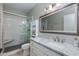 Bright bathroom with a glass-enclosed shower, white vanity, and a large mirror at 1411 E Orangewood Ave # 237, Phoenix, AZ 85020
