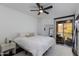 A bright bedroom with white walls, dark wood floors, and sliding door access to the balcony at 1411 E Orangewood Ave # 237, Phoenix, AZ 85020