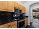Modern kitchen featuring updated appliances, granite countertops, and wooden cabinets for a stylish cooking space at 1411 E Orangewood Ave # 237, Phoenix, AZ 85020