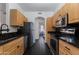 A functional kitchen with stainless steel appliances, granite counters, and wood cabinets for efficient meal preparation at 1411 E Orangewood Ave # 237, Phoenix, AZ 85020