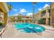 Community pool featuring a hot tub, lounging chairs and mature palm trees at this gorgeous condo at 1411 E Orangewood Ave # 237, Phoenix, AZ 85020