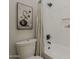 Bathroom with white subway tile, shower/tub combo, toilet, and decorative accents at 1444 E Boston St, Chandler, AZ 85225