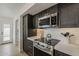 Close-up of kitchen featuring stainless steel appliances, white countertops, and dark cabinets at 1444 E Boston St, Chandler, AZ 85225