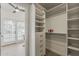 A bright, organized walk-in closet with shelving and drawers, located near a sunny room with outside access at 1444 E Boston St, Chandler, AZ 85225