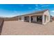 Spacious backyard with covered patio, rock landscaping, and privacy wall at 16981 W Cameron Dr, Surprise, AZ 85388