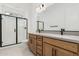 Modern bathroom featuring double vanity, wood cabinets, matte black fixtures, and walk-in shower at 16981 W Cameron Dr, Surprise, AZ 85388