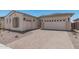 Two-car garage with desert landscaping and a brick driveway leading up to the house at 16981 W Cameron Dr, Surprise, AZ 85388