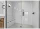 Spa-like shower with glass door, bench seating, and modern white tile at 16981 W Cameron Dr, Surprise, AZ 85388