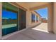 Covered back patio with sliding glass doors opens to a spacious dirt backyard at 17304 W Royal Palm Rd, Waddell, AZ 85355