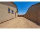 Spacious dirt backyard enclosed by a block wall and gate, offering privacy and potential at 17304 W Royal Palm Rd, Waddell, AZ 85355
