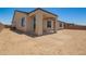 Exterior view of a single-story home with a covered patio and spacious dirt backyard at 17304 W Royal Palm Rd, Waddell, AZ 85355