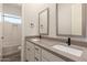 Stylish bathroom with double sinks, modern fixtures, and tiled shower is move-in ready at 17304 W Royal Palm Rd, Waddell, AZ 85355