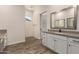 Bathroom featuring white cabinets, modern fixtures, and natural lighting at 17304 W Royal Palm Rd, Waddell, AZ 85355