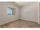Bright bedroom features a wood-look floor, natural light from the window, and neutral paint at 17304 W Royal Palm Rd, Waddell, AZ 85355
