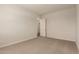 Neutral bedroom features neutral carpet and a door leading to other rooms at 17304 W Royal Palm Rd, Waddell, AZ 85355