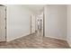 Neutral bedroom with a wood-look floor, white trim, and a door leading to other rooms at 17304 W Royal Palm Rd, Waddell, AZ 85355