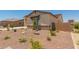 Well-maintained single Gathering home features desert landscaping with small trees and neutral color palette at 17304 W Royal Palm Rd, Waddell, AZ 85355
