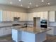 Open kitchen with white cabinets, island, gas cooktop, built in oven, and wood look flooring at 17304 W Royal Palm Rd, Waddell, AZ 85355