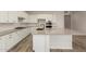 Modern kitchen with white cabinetry, granite countertops, stainless steel appliances and wood-style flooring at 17304 W Royal Palm Rd, Waddell, AZ 85355