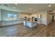 Expansive kitchen with white cabinets, stainless appliances, large island, and wood-look floors at 17304 W Royal Palm Rd, Waddell, AZ 85355