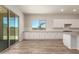 Spacious kitchen with white cabinetry, stainless steel appliances, tile backsplash, and wood-style flooring at 17304 W Royal Palm Rd, Waddell, AZ 85355