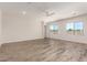 Bright open living room features a neutral color palette, wood-style floors, and large windows at 17304 W Royal Palm Rd, Waddell, AZ 85355