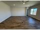 Sunlit living room featuring wood-look floors, neutral walls, a ceiling fan and bright, airy ambiance at 17304 W Royal Palm Rd, Waddell, AZ 85355