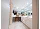 Bright bathroom featuring a mirrored wall, white cabinetry, and a cozy vanity area with a decorative chair and tile flooring at 17404 N 99Th Ave # 126, Sun City, AZ 85373