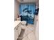 Well-lit bathroom featuring a dolphin-themed shower curtain and tiled flooring at 17404 N 99Th Ave # 126, Sun City, AZ 85373