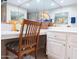 Bright bathroom featuring a mirrored wall, white cabinetry, and a cozy vanity area with a decorative chair and tile flooring at 17404 N 99Th Ave # 126, Sun City, AZ 85373