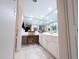 Bright bathroom featuring a mirrored wall, white cabinetry, and a cozy vanity area with a decorative chair and tile flooring at 17404 N 99Th Ave # 126, Sun City, AZ 85373