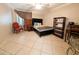 Comfortable bedroom featuring tile flooring, a queen-sized bed, and coordinated furnishings at 17404 N 99Th Ave # 126, Sun City, AZ 85373
