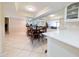Bright dining room featuring a dark wood table and chairs, and a mirrored wall that reflects the adjacent living room and kitchen at 17404 N 99Th Ave # 126, Sun City, AZ 85373